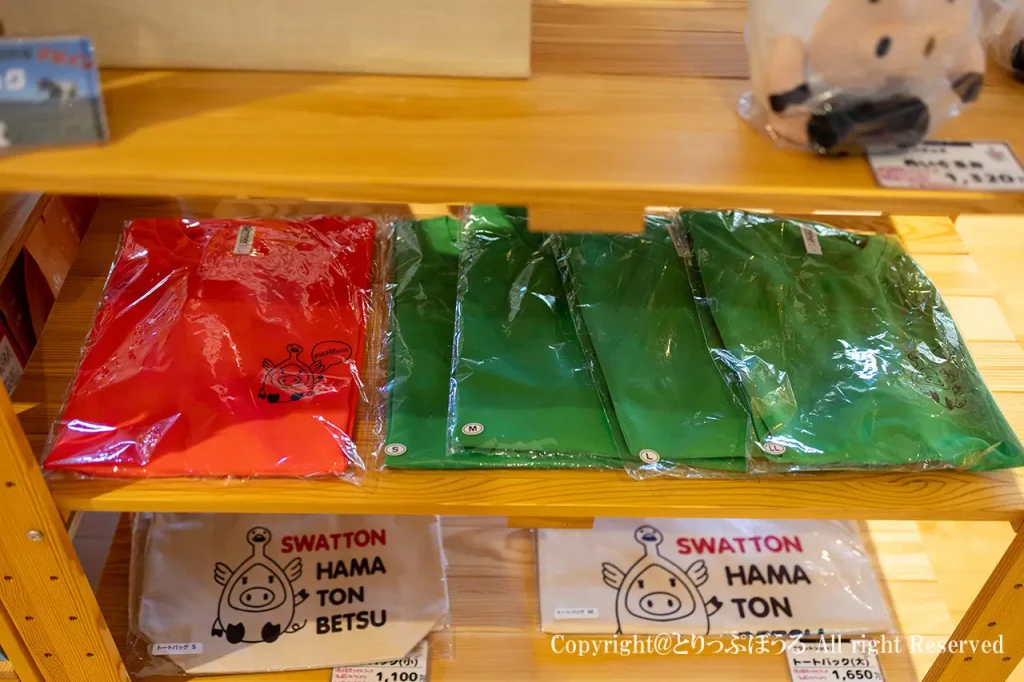 道の駅はまとんべつで販売されているスワットンのTシャツやエコバッグなどの限定グッズ