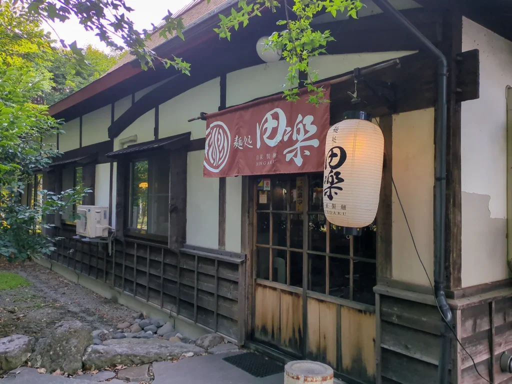 暖簾と提灯が掛かる昭和レトロな古民家風の麺処田楽の外観